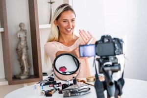 hermosa joven bloguera grabando video vlog con maquillaje cosmético en casa influenciador en línea en el concepto de redes sociales. transmisión en vivo viral foto