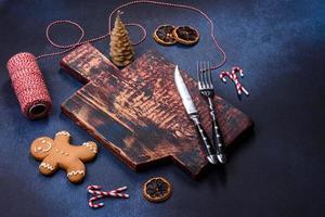 Elements of Christmas decorations, sweets and gingerbread on a wooden cutting board photo