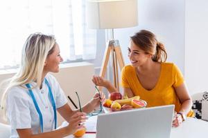 médico nutricionista, dietista y paciente femenino en consulta en el consultorio. nutricionista femenina dando consulta al paciente. hacer un plan de dieta. foto