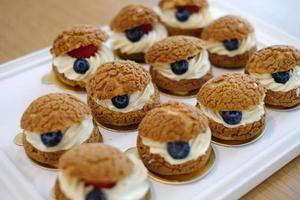 Homemade choux cream or cream puffs with custard cream and strawberry. Homemade bakery concept. photo