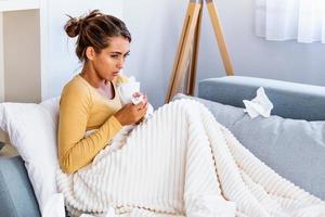 Sick desperate woman has flu. Rhinitis, cold, sickness, allergy concept. Pretty sick woman has runnning nose, rubs nose with handkerchief. Sneezing female.