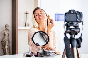 hermosa mujer natural belleza profesional vlogger o blogger transmisión en vivo tutorial de maquillaje cosmético video clip viral por cámara compartida en las redes sociales foto