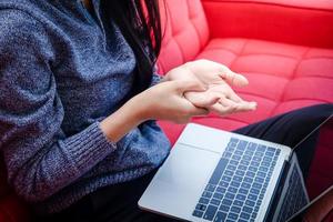 Asian women work at home during the coronavirus. Massage the fingers to get rid of the pain. Because she works all day. The concept of social distance. Office Syndrome Health Problems photo