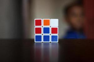 Rubik's cube on the black background. Rubik's Cube was invented by Hungarian architect Erno Rubik in 1974. photo