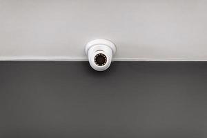 White security CCTV Camera or surveillance operating on ceiling inside room with copy space. High quality photo