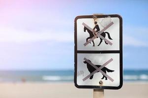 letrero en la playa están prohibidos los perros y está prohibido montar a caballo. advertencia en la playa que está prohibido hacer. foto de alta calidad