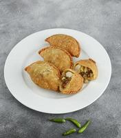 Kue pastel, traditional savory snack from Indonesia filled with carrots, potatoes and egg, eat with chili or sauce. Selective focus photo