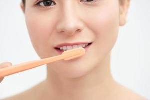 mujer joven sonriente con dientes sanos sosteniendo un cepillo de dientes foto