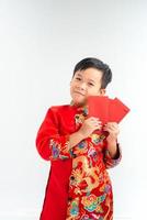 Little Vietnamese boy holding red envelops for Tet. The word mean double happiness. It is the gift in lunar new year or Tet Holiday on isolate background photo