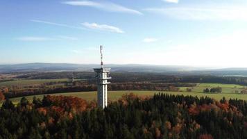 Aerial ascending view of a radio tower in autumn forest video
