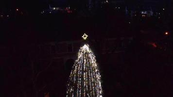 antenne bodem naar beneden dichtbij visie van een Kerstmis boom in dorp video