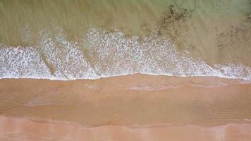 Luftbild von oben nach unten auf das Meer mit Wellen an einem Sandstrand von Portimao video