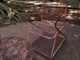 rusty iron chairs and tables on the terrace in a shady ambience. This photo can be used for everything related to nature, exterior, terrace, house and residence, plants, garden, backyard