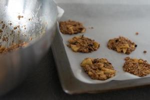 Baked cookies on a oven tray. Metal bowl photo