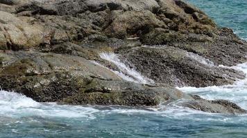 turquoise golven rolden op de rotsen, nai harn strand ten zuiden van phuket eiland, slow motion video