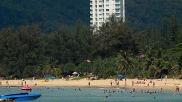 mensen kom tot rust Aan Karon strand. deze is een van de meest populair stranden tussen toeristen in phuket video