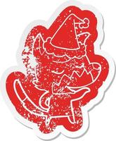 friendly cartoon distressed sticker of a fox wearing santa hat vector