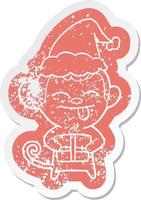 funny cartoon distressed sticker of a monkey with christmas present wearing santa hat vector