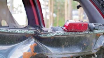 un automóvil después de un accidente con una ventana trasera rota. ventana rota en un vehículo con luz de freno trasera. restos interiores, vista detallada de primer plano de un coche moderno dañado. video