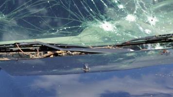 agujero de bala en la puerta de un coche. coche abandonado con agujeros de bala. un vehículo destruido en una zona de guerra en ucrania. coche civil dañado. el automóvil resultó dañado por metralla como resultado de las hostilidades. video