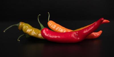 assorted hot chili peppers on a dark background photo