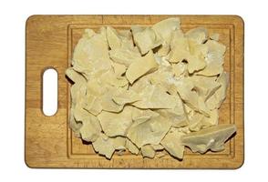 Pieces of cocoa butter on a wooden board. Cocoa butter is an ingredient for making chocolate. Chunks of cocoa butter before grinding. photo