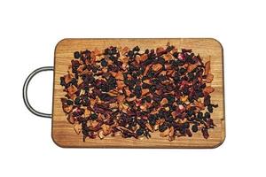 Background texture fragrant dry black tea with fruits and petals. Isolate on a wooden board. Tea with a predominance of dry raspberries photo