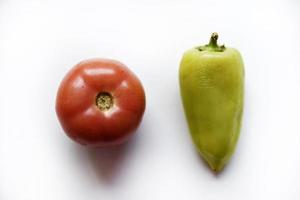 Green pepper and red tomato on a white background. Vegetables close-up. photo