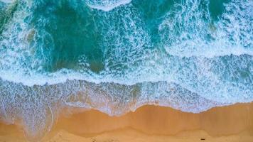 Beautiful sea waves and white sand beach in the tropical island. Soft waves of blue ocean on sandy beach background from top view from drones. Concept of relaxation and travel on vacation. photo