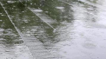 las gotas de lluvia golpean el techo, lluvia intensa, aguacero. la cubierta plana del edificio está cubierta con un material impermeable que protege de la lluvia. ruberoid, material para techos laminados e impermeabilizantes. video