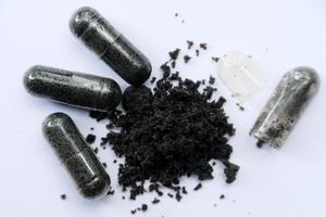 Black cumin capsules isolated on a black background photo