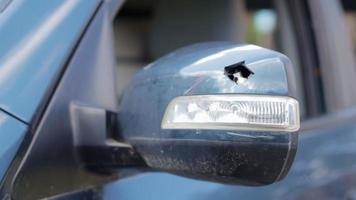 dichtbij omhoog gebroken links kant achterzijde visie spiegel van een auto in blauw. auto verzekering concept. gebroken kant venster van de auto Aan de bestuurder kant net zo een resultaat van een ongeluk. crimineel incident. video