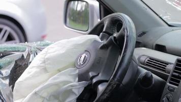 Focus on the steering wheel of the car and the deployed airbag. Airbag on the driver's side on the wheel after a car accident. Panorama. Driver's side airbag. Ukraine, Irpin - May 12, 2022. video