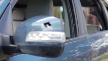 Schließen Sie den kaputten linken Rückspiegel eines Autos in Blau. Autoversicherungskonzept. zerbrochene Seitenscheibe des Autos auf der Fahrerseite infolge eines Unfalls. krimineller Vorfall. video