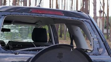 un automóvil después de un accidente con una ventana trasera rota. ventana rota en un vehículo. los restos del interior de un automóvil moderno después de un accidente, una vista detallada de primer plano del automóvil dañado. video