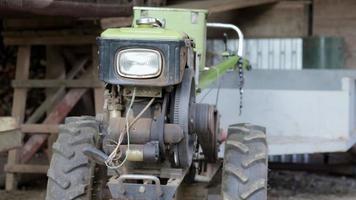 Typical heavy diesel walking tractor with trailer. Agricultural transport equipment of the countryside. Portable agricultural equipment, walking minitractor. The start system is mechanical and manual. video