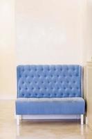 elegante sofá clásico azul terciopelo en salón blanco. sala de luz real. hermoso sillón. interior clásico y elegante con colores azul y blanco. habitación de huéspedes foto
