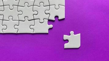 Jigsaw puzzle on purple background with customizable space for text or ideas. Copy space photo