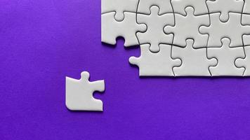 Jigsaw puzzle on purple background with customizable space for text or ideas. Copy space photo