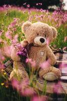 Teddy bear and a bouquet of lilac flowers. toy bag with a bouquet of flowers. spring flowers photo