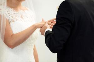 Wedding rings. Her Put the Wedding Ring on He. Close up Bride Put the Ring on Groom. thai wedding ceremony and thai wedding decoration. Bride Put the Ring on Groom's finger. photo