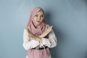 Beautiful Asian Muslim woman with hand gesture pose rejection or prohibition with copy space photo