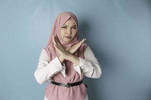 Beautiful Asian Muslim woman with hand gesture pose rejection or prohibition with copy space photo