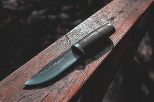 Hunting knife on a wooden surface photo