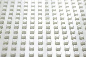 Diagonal view of a large number of neatly arranged plastic buttons cylinder for background. photo