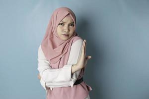 hermosa mujer musulmana asiática con gesto de mano plantea rechazo o prohibición con espacio de copia foto