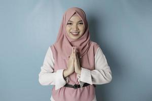 Portrait young beautiful Muslim woman wearing a pink hijab. Eid Mubarak greeting photo
