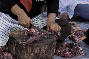 A portrait of Muslims cutting meat on Eid Al Adha by using cutting knife photo