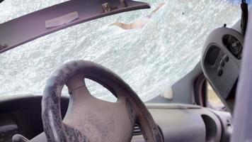 Cracked car windshield after an accident. Close-up of a wrecked car after a collision with a pedestrian or car accident. Damaged vehicle. View from inside the cabin. Ukraine, Irpin - May 12, 2022. video