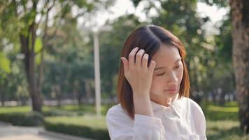 Asian girl listening to heart-warming music in the pine forest park in the park. video